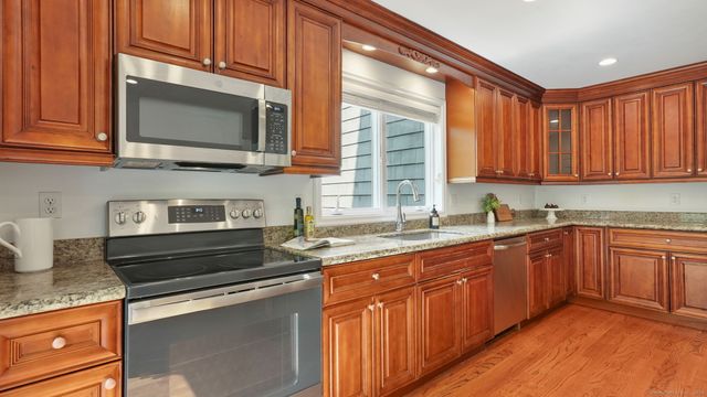 a kitchen with stainless steel appliances granite countertop a sink stove and microwave
