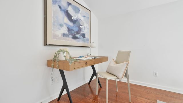 a view of a workspace with furniture and wooden floor