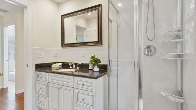a bathroom with a granite countertop sink and a mirror