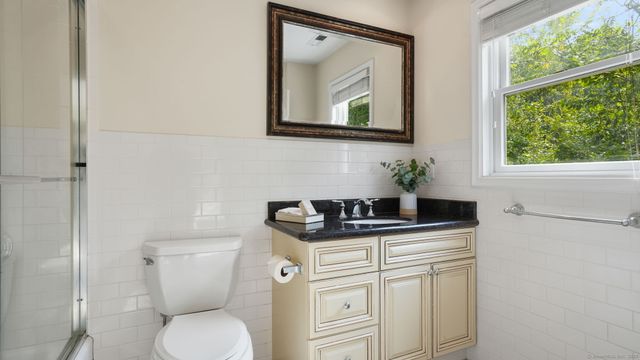a bathroom with a granite countertop toilet sink and mirror