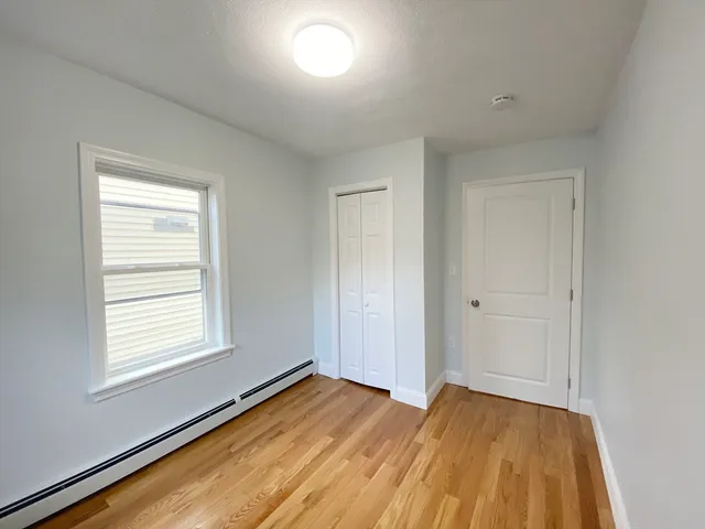 a view of a room with wooden floor and window