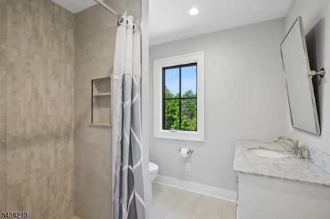 a bathroom with a granite countertop sink toilet and shower