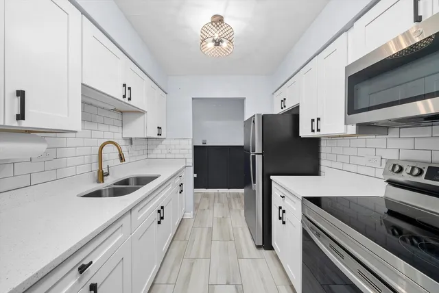 a kitchen with a sink and a stove top oven