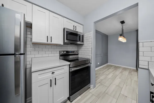 a kitchen with stainless steel appliances granite countertop a refrigerator and a stove top oven