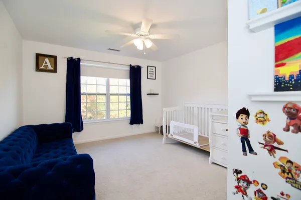 a living room with a baby crib furniture and a chandelier