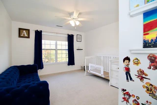 a living room with a baby crib furniture and a chandelier