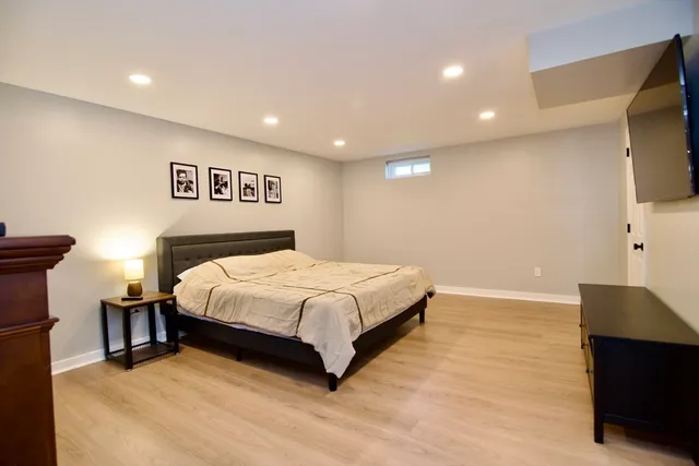 a large bedroom with a bed and a flat screen tv