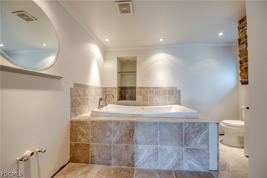 2701 Bruce Street Matlacha, FL 33993 - Photo 27 of 47 a bathroom with a granite countertop sink a toilet a mirror and bathtub