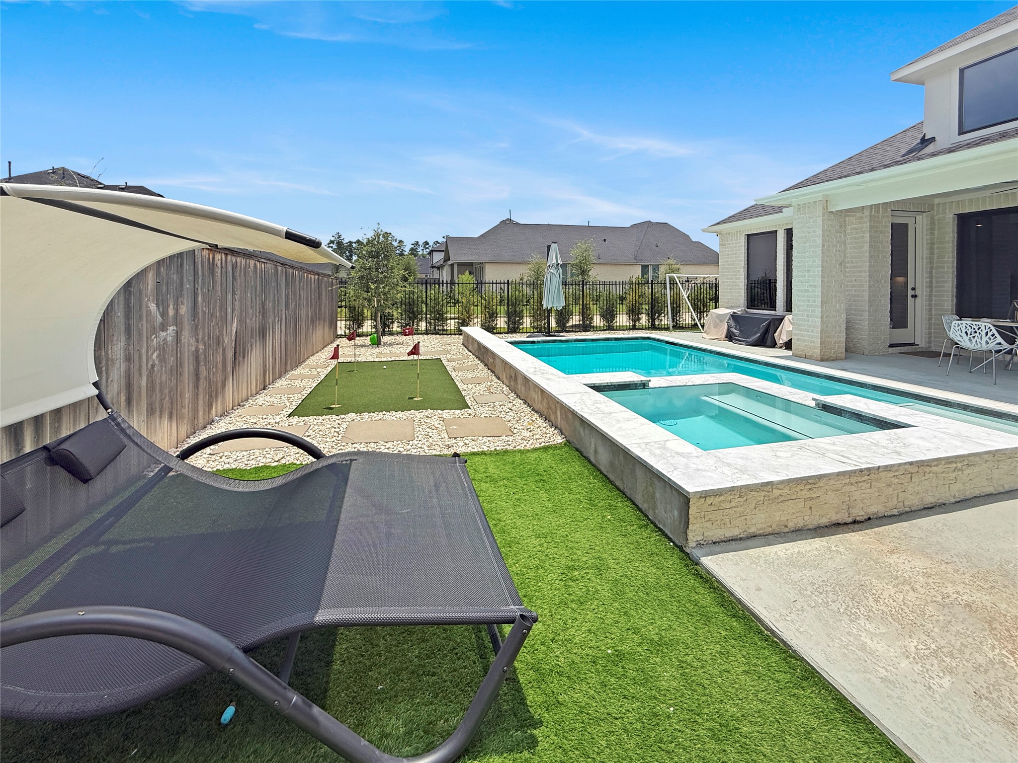 26918 Swanborough Road Spring, TX 77389 - Photo 40 of 50 The outdoor entertaining spaces are warm and welcoming, with plenty of room for gathering and relaxing — and a private putting green adds a fun, unexpected touch for golf enthusiasts.