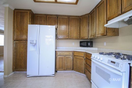 408 South Valley Street Ridgecrest, CA 93555 - Photo 10 of 29 a kitchen with a white stove refrigerator and cabinets
