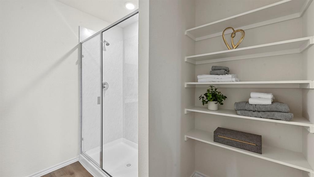 Full bath with a stall shower and wood finished floors