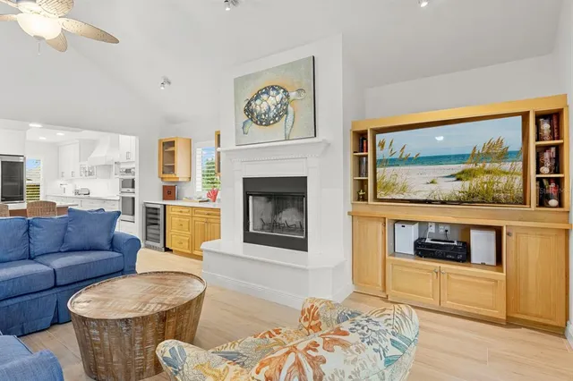 a kitchen with stainless steel appliances granite countertop a sink a stove a refrigerator cabinets and a dining table