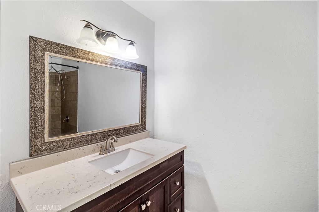 12411 Osborne Street, Unit 2 Pacoima, CA 91331 - Photo 20 of 37 a bathroom with a granite countertop sink and a mirror