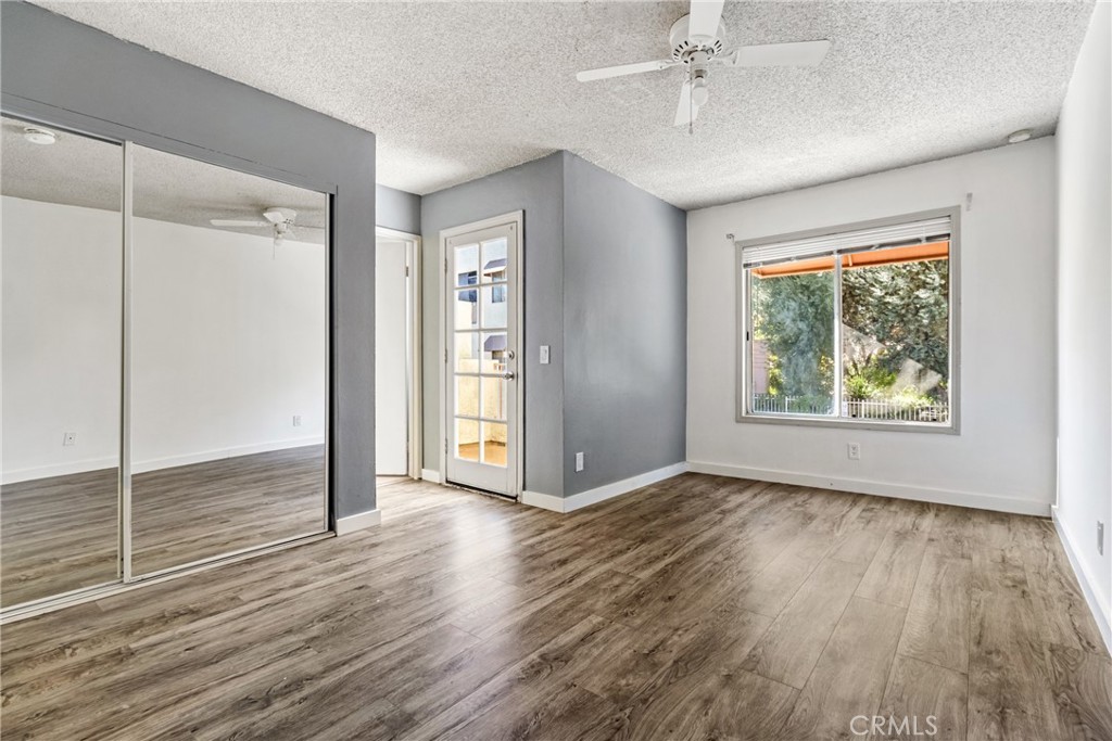 12411 Osborne Street, Unit 2 Pacoima, CA 91331 - Photo 24 of 37 an empty room with wooden floor and windows