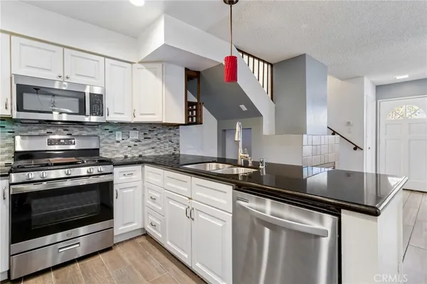 a kitchen with stainless steel appliances granite countertop a sink stove and refrigerator