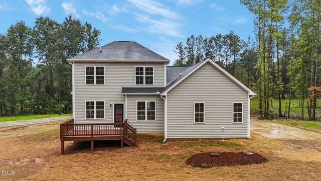 a view of a white house with a yard and roof