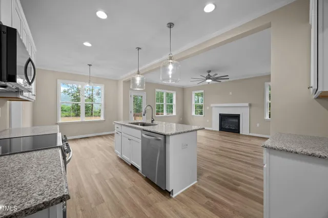 a large kitchen with granite countertop a stove oven and a wooden floor