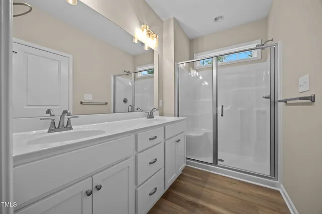a spacious bathroom with a double vanity sink mirror and shower