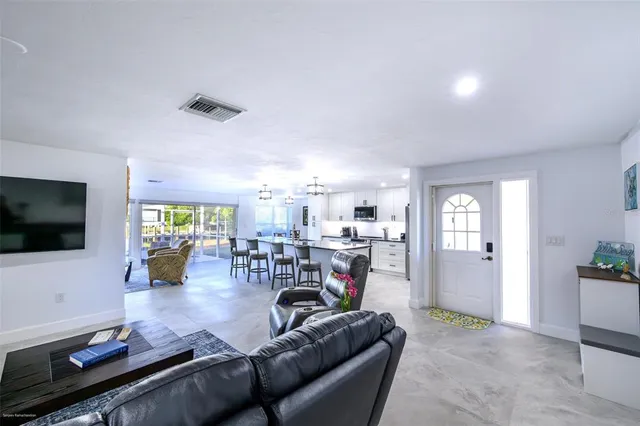 a kitchen with a dining table chairs and refrigerator