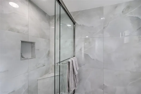 a bathroom with a granite countertop toilet a sink a mirror and shower