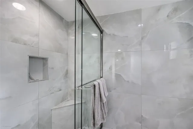 a bathroom with a granite countertop toilet a sink a mirror and shower