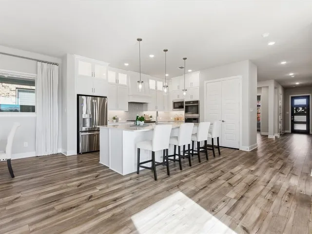 a kitchen with stainless steel appliances kitchen island granite countertop a refrigerator and a stove top oven