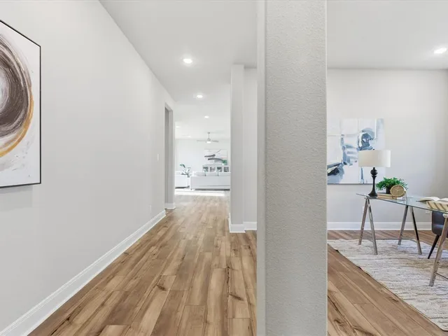 a view of a hallway with wooden floor and a sink