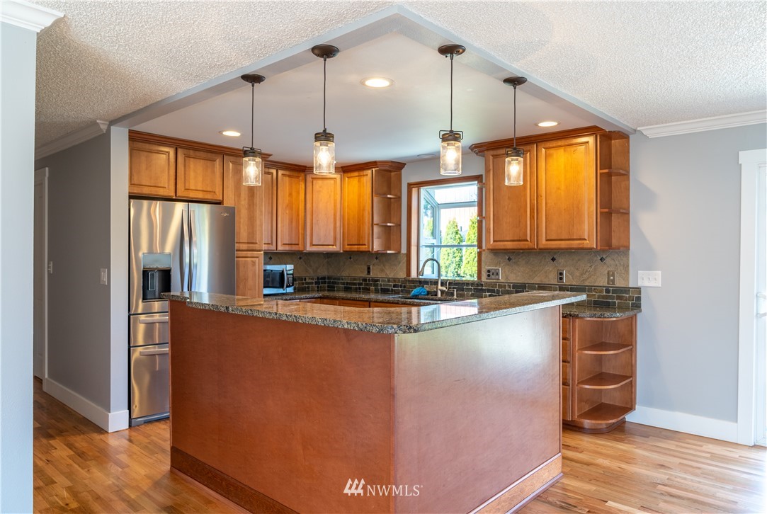 407 216th Street Southwest Bothell, WA 98021 - Photo 4 of 18 a large kitchen with kitchen island a large window a sink and stainless steel appliances