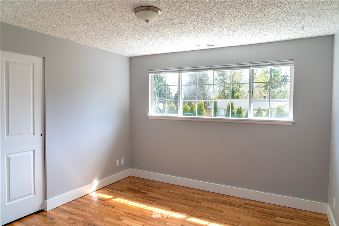 407 216th Street Southwest Bothell, WA 98021 - Photo 8 of 18 an empty room with wooden floor and windows