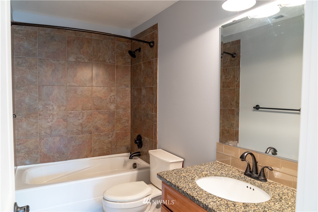 407 216th Street Southwest Bothell, WA 98021 - Photo 9 of 18 a bathroom with a granite countertop sink toilet mirror and shower
