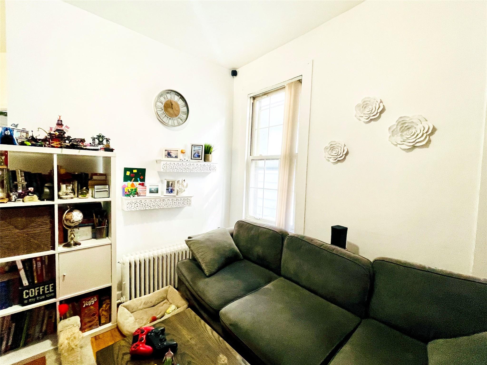 83-10 Pettit Avenue Queens, NY 11373 - Photo 6 of 7 Living area featuring radiator and wood finished floors