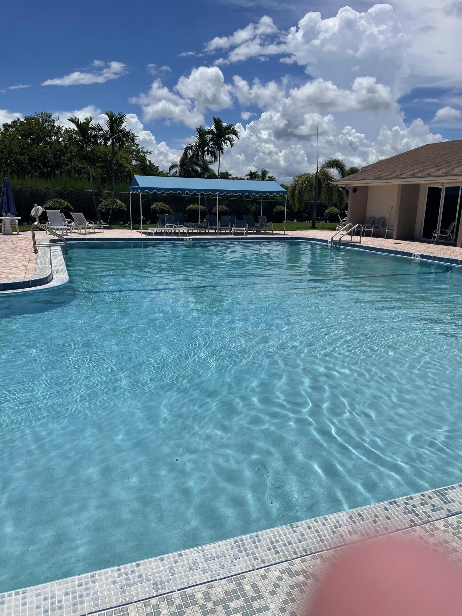 506 Davis Road, Unit 78 Palm Springs, FL 33461 - Photo 33 of 58 a view of a swimming pool with lawn chairs and a fire pit