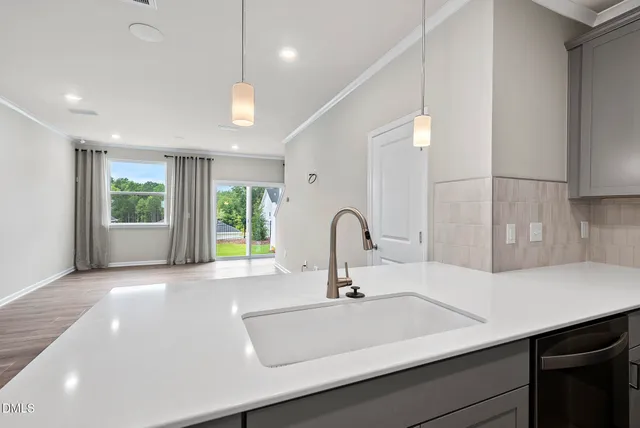 a kitchen with a sink a counter space and a dining table