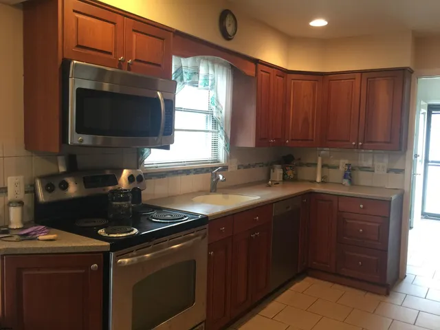 a kitchen with a sink and a stove top oven with wooden floor