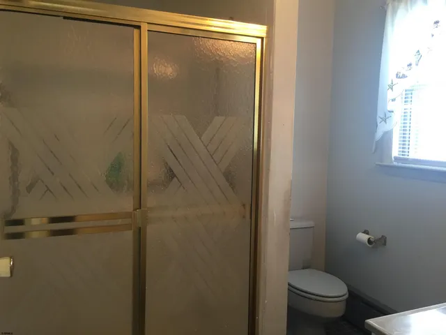 a bathroom with a granite countertop toilet and a shower