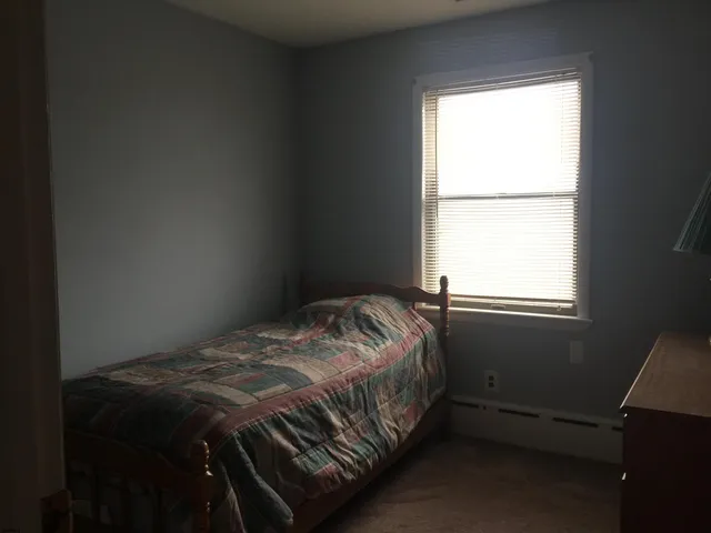 a bed sitting in a bedroom next to a window