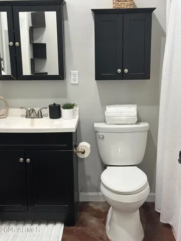 a bathroom with a toilet a sink and mirror