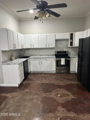 a kitchen with stainless steel appliances granite countertop a stove a refrigerator a sink a stove with white cabinets