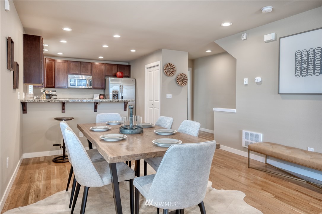 946 North 96th Street Seattle, WA 98103 - Photo 12 of 24 a dining room with stainless steel appliances kitchen island granite countertop a dining table and chairs