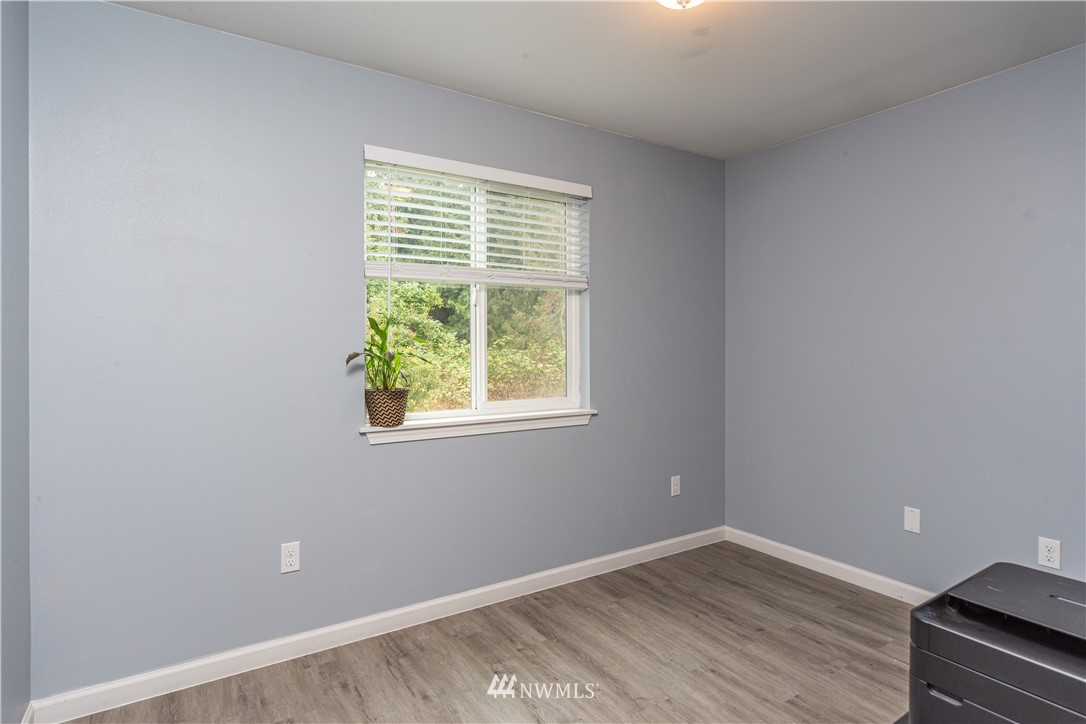 124 Fitzgerald Road Sequim, WA 98382 - Photo 14 of 25 an empty room with wooden floor and windows