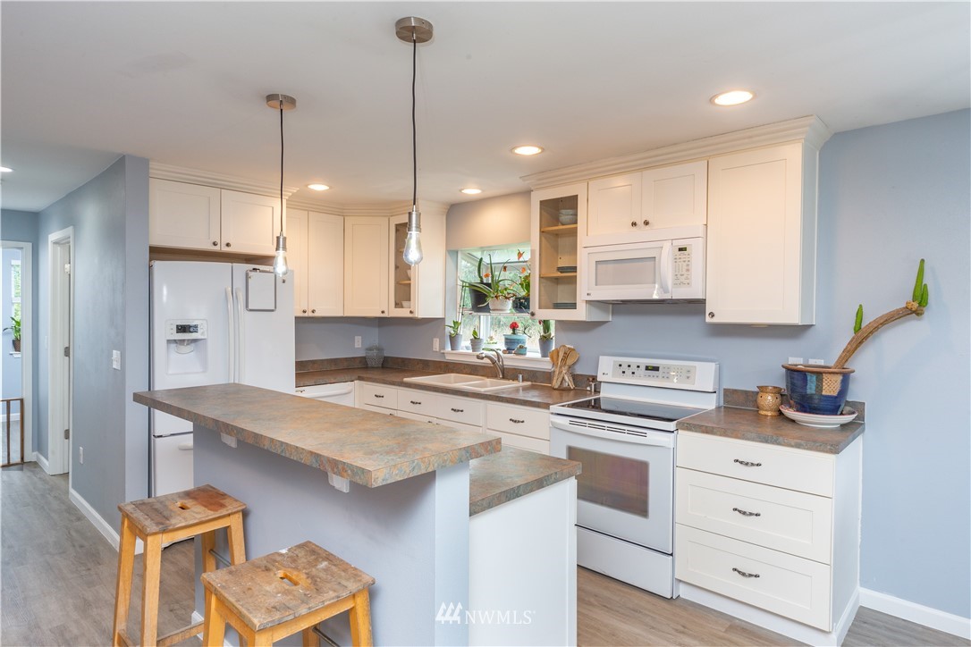 124 Fitzgerald Road Sequim, WA 98382 - Photo 5 of 25 a kitchen with a stove a sink a refrigerator a center island and cabinets
