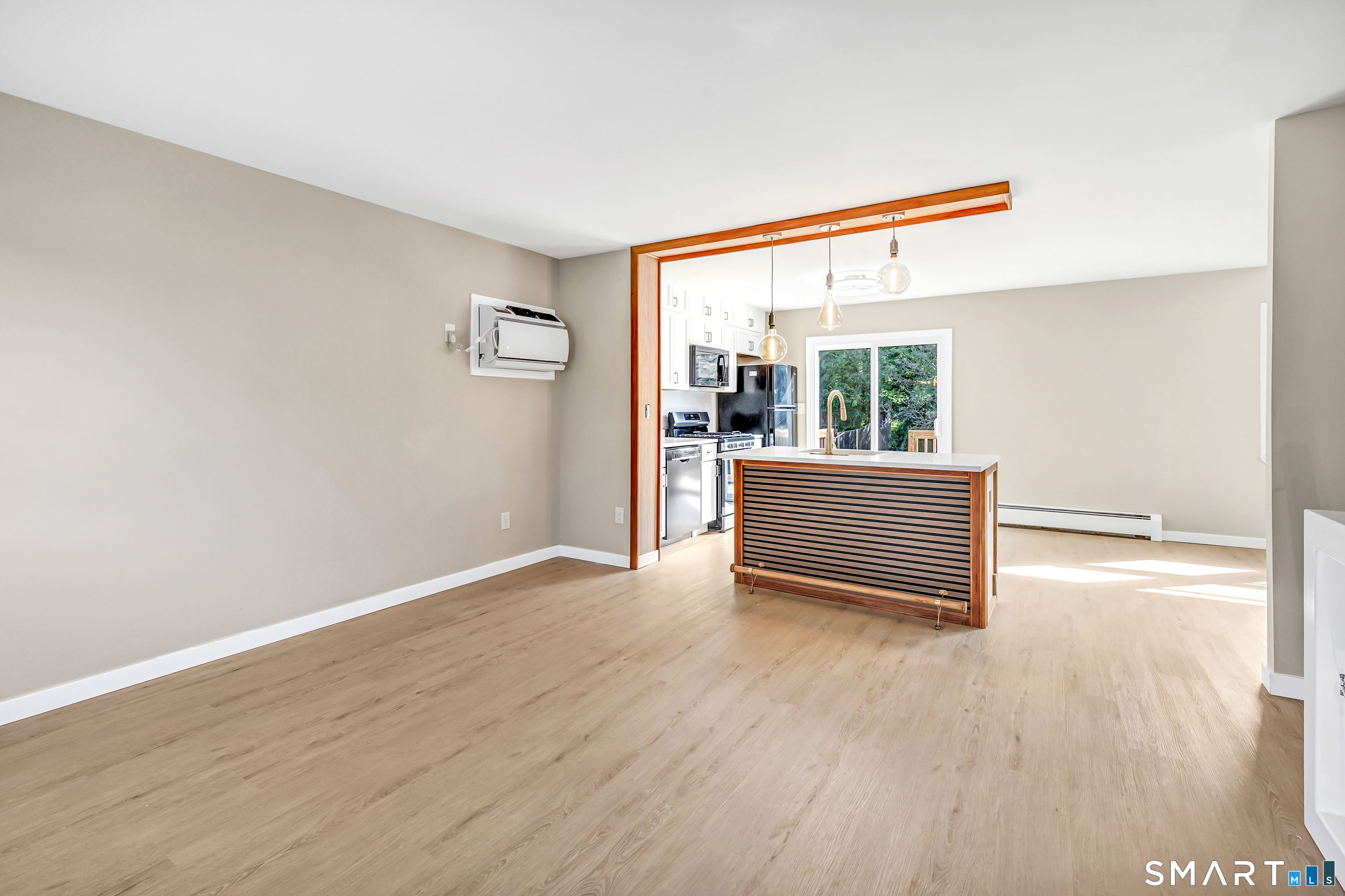 77 Meadow Lark Road Naugatuck, CT 06770 - Photo 10 of 40 Kitchen - White cabinetry, white quartz counter tops with matching custom built island w/ deep sink & electrical outlets, New Sliding Door that leads to rear deck, Freshly painted, installed luxury vinyl floor on both floors,