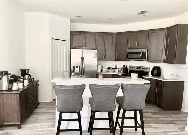 a kitchen with a table chairs microwave and cabinets