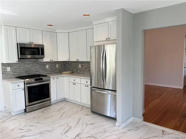 a kitchen with granite countertop a refrigerator stove and microwave