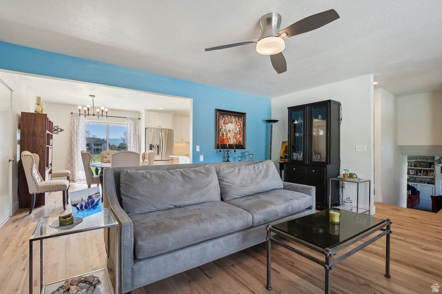 550 Pine Canyon Road Midway, UT 84049 - Photo 6 of 44 Living area featuring wood-finish flooring, a contemporary ceiling fan with integrated lighting, and a partial accent wall