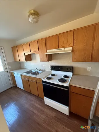 a kitchen with wooden cabinets and a stove top oven