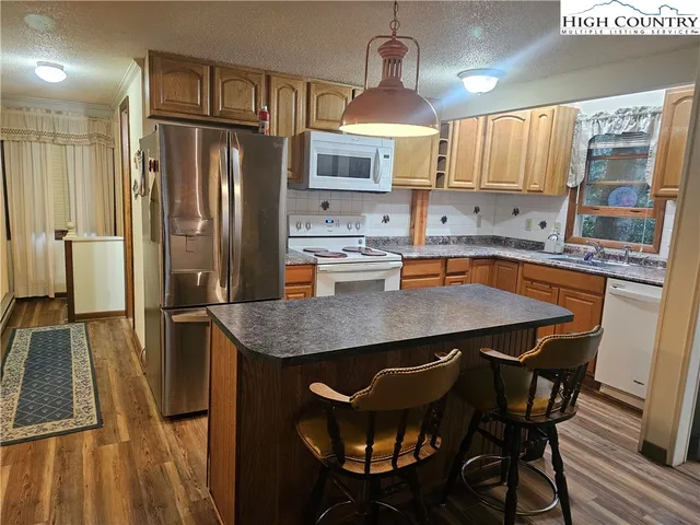 a kitchen with stainless steel appliances a dining table chairs refrigerator and stove