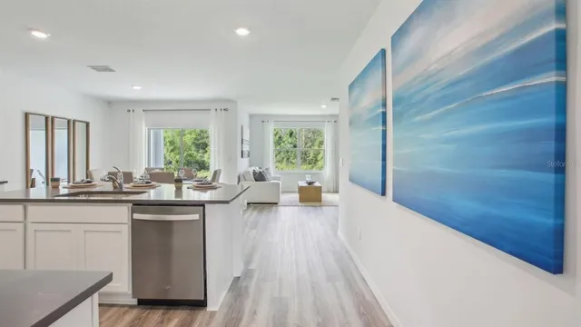 a kitchen with stainless steel appliances granite countertop a refrigerator a sink a stove and a refrigerator with wooden floor