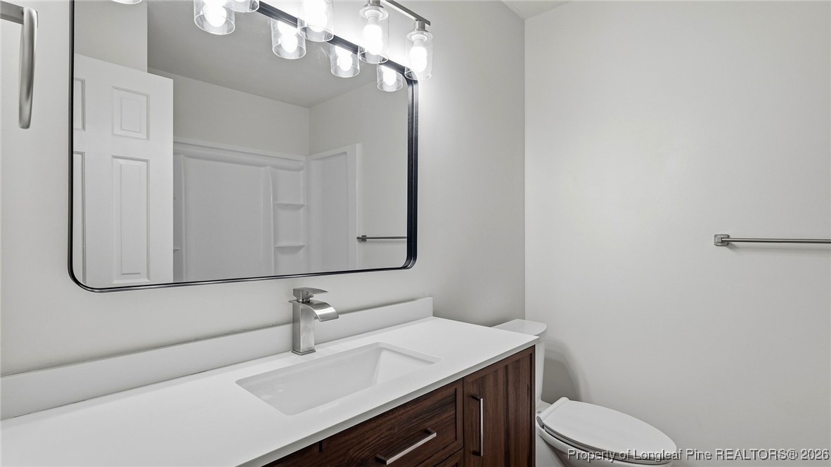 10765 Barker 10 Mile Road St. Pauls, NC 28384 - Photo 12 of 48 a bathroom with a sink vanity mirror and toilet