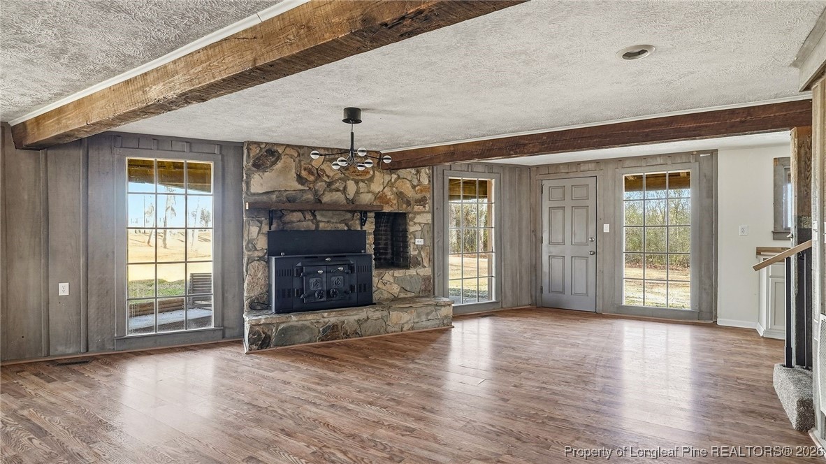 10765 Barker 10 Mile Road St. Pauls, NC 28384 - Photo 19 of 48 an empty room with wooden floor fireplace and windows
